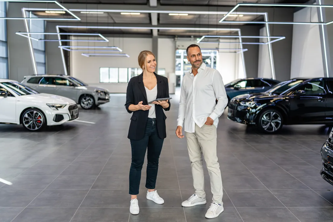 Zwei Mitarbeitende im Gespräch in einer Fahrzeughalle